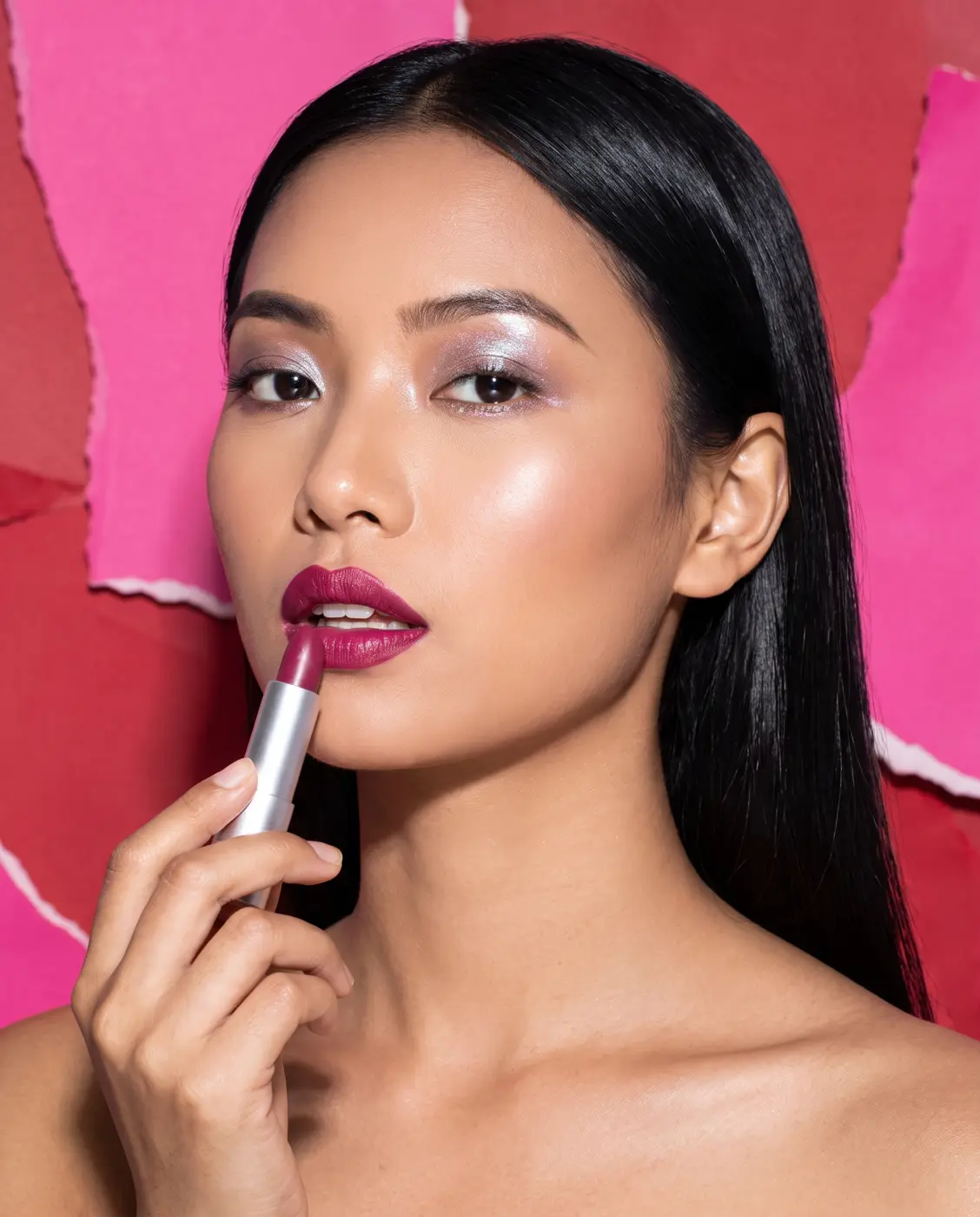 Model with bold makeup holding a lipstick