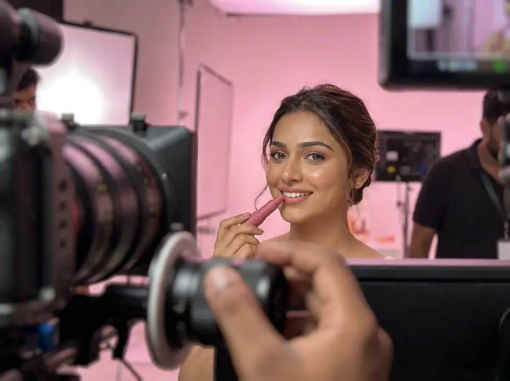 Model holding a lipstick on a cosmetics video shoot