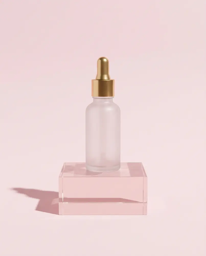 Serum bottle product photo on a pink block