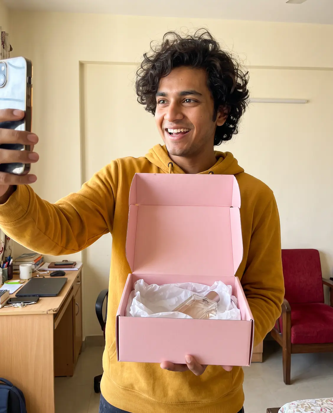 Creator unboxing a pink package with a perfume bottle